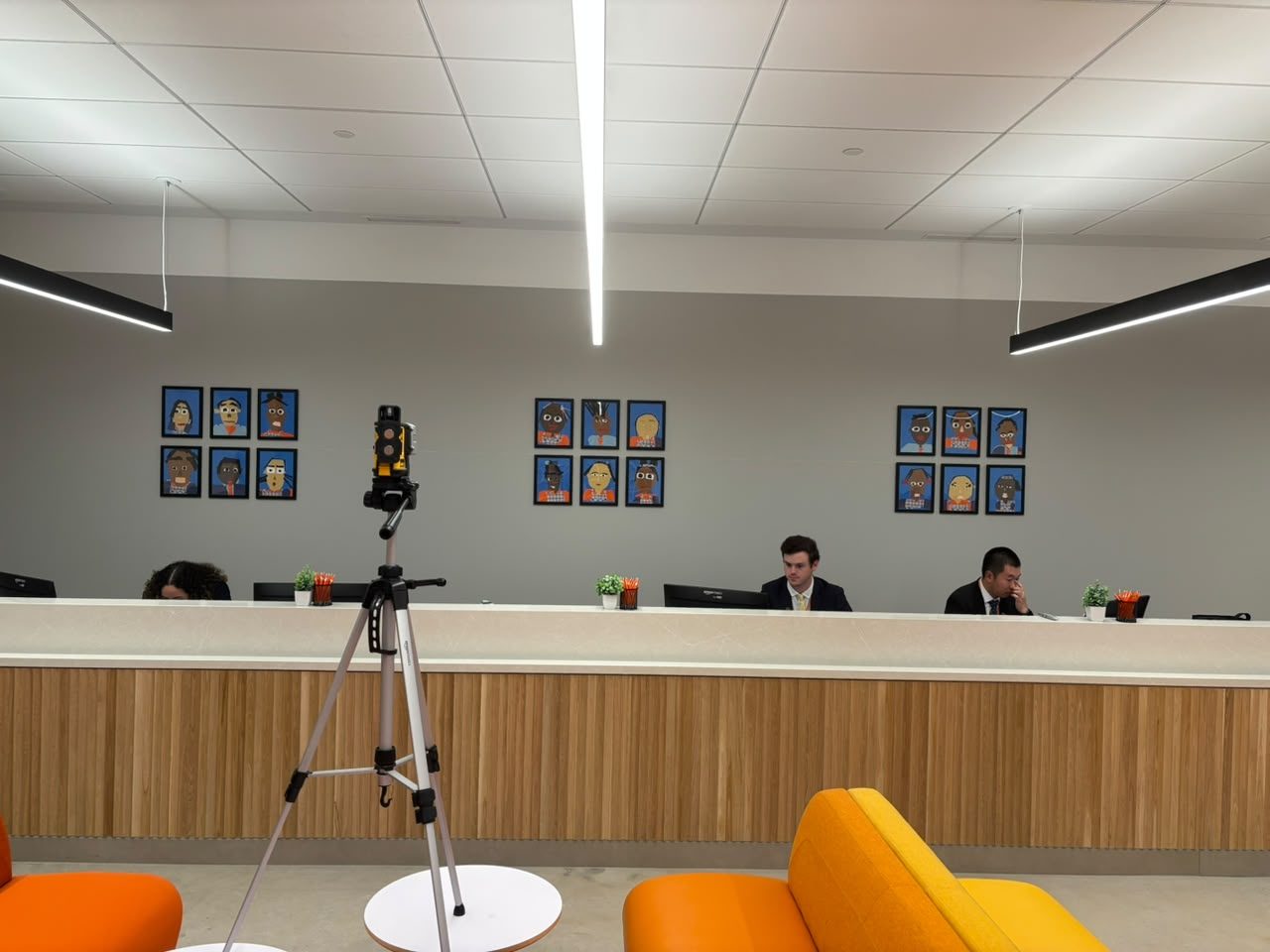 Framed artwork grids installed above a reception desk